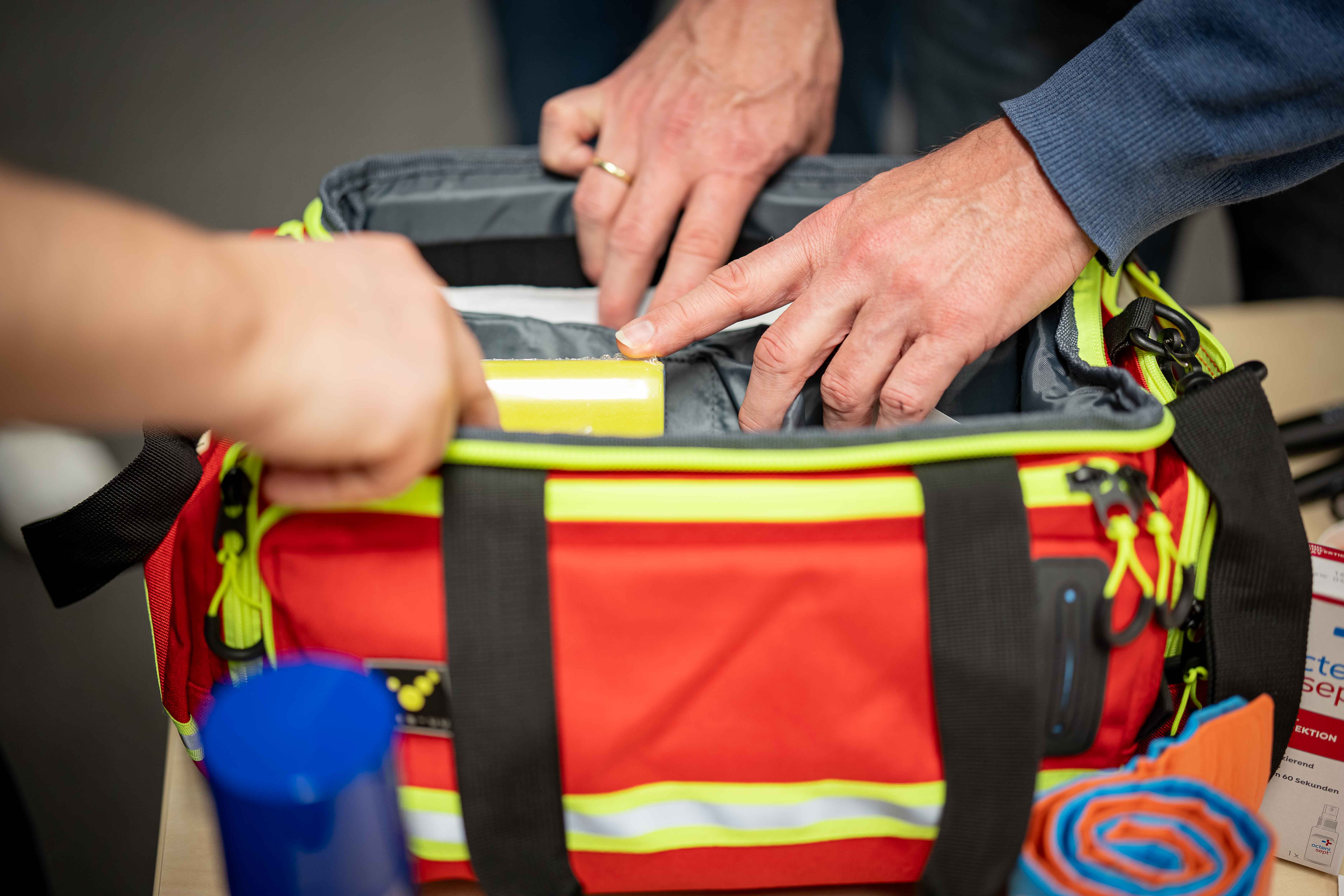 Griff in die vom ASB zusammengestellten Erste-Hilfe-Tasche für den Sport